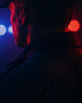 Officer portrait illuminated by red and blue lights