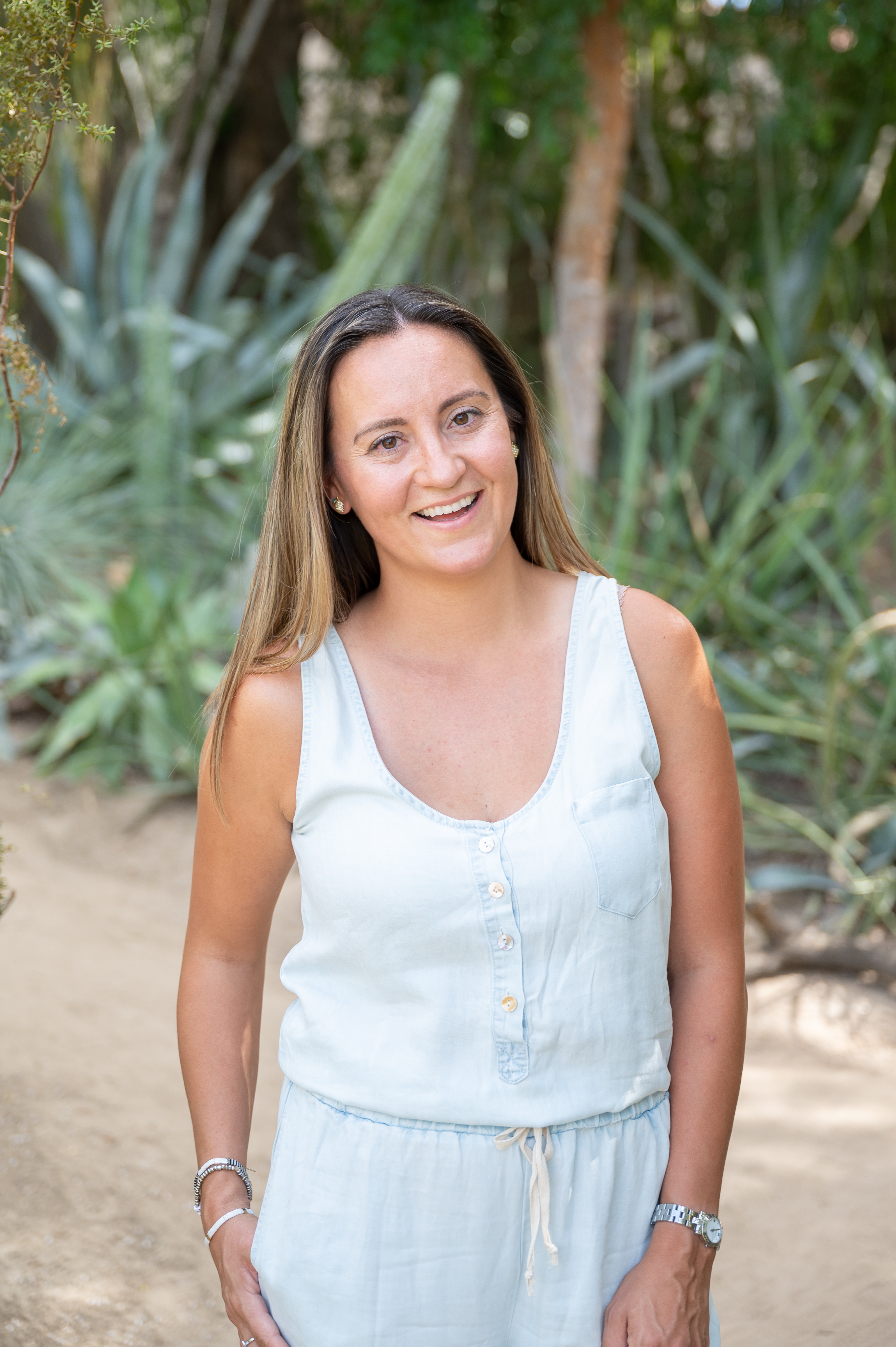 Pam, founder of Point Hope Wellness, smiling outdoors among coastal greenery