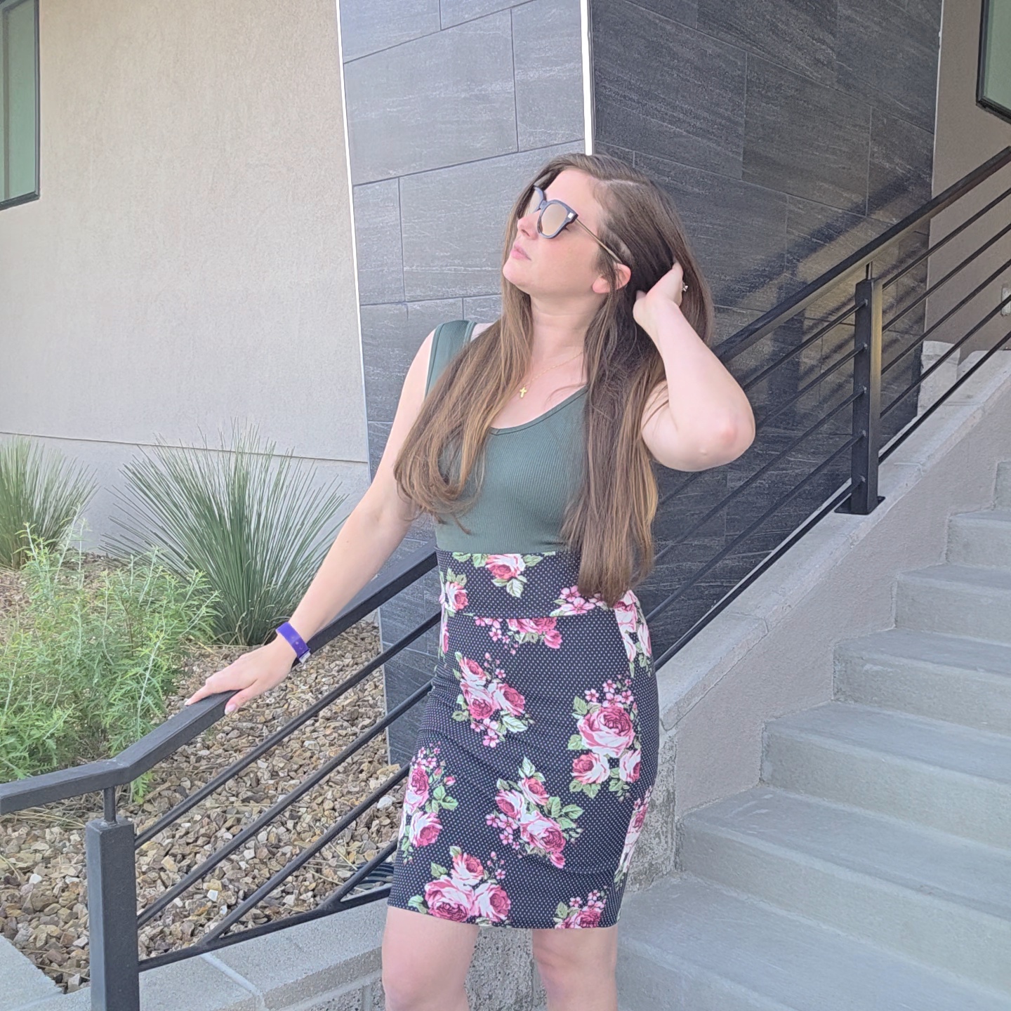 Courtney wearing a green jumpsuit layered over a floral top