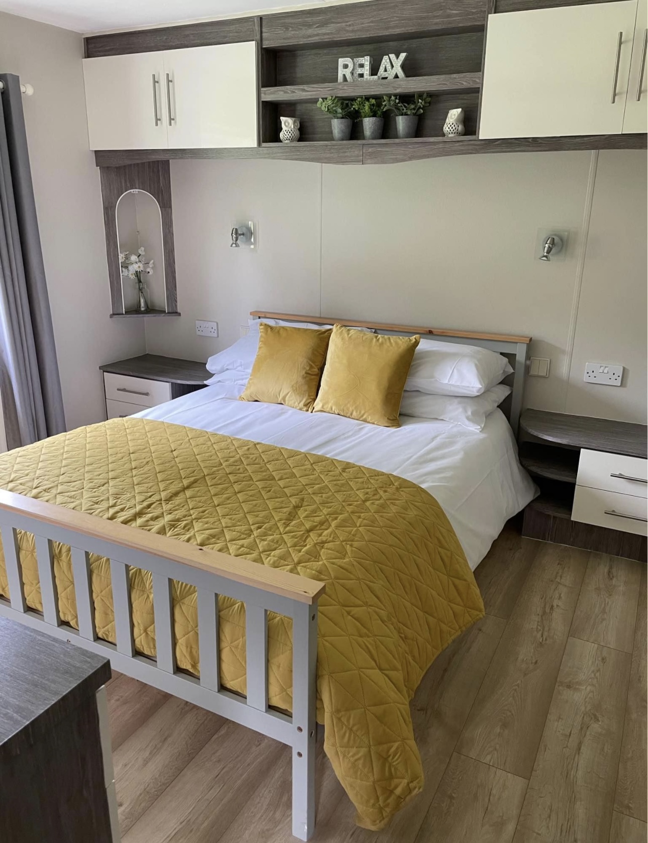 Illustrative Hafan y Môr lodge bedroom with a double bed and mustard bedding