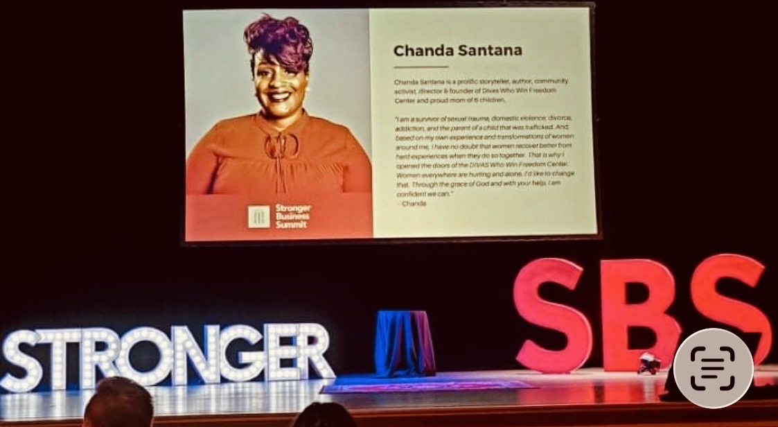 Chanda Santana featured on a screen at the Stronger Business Summit stage