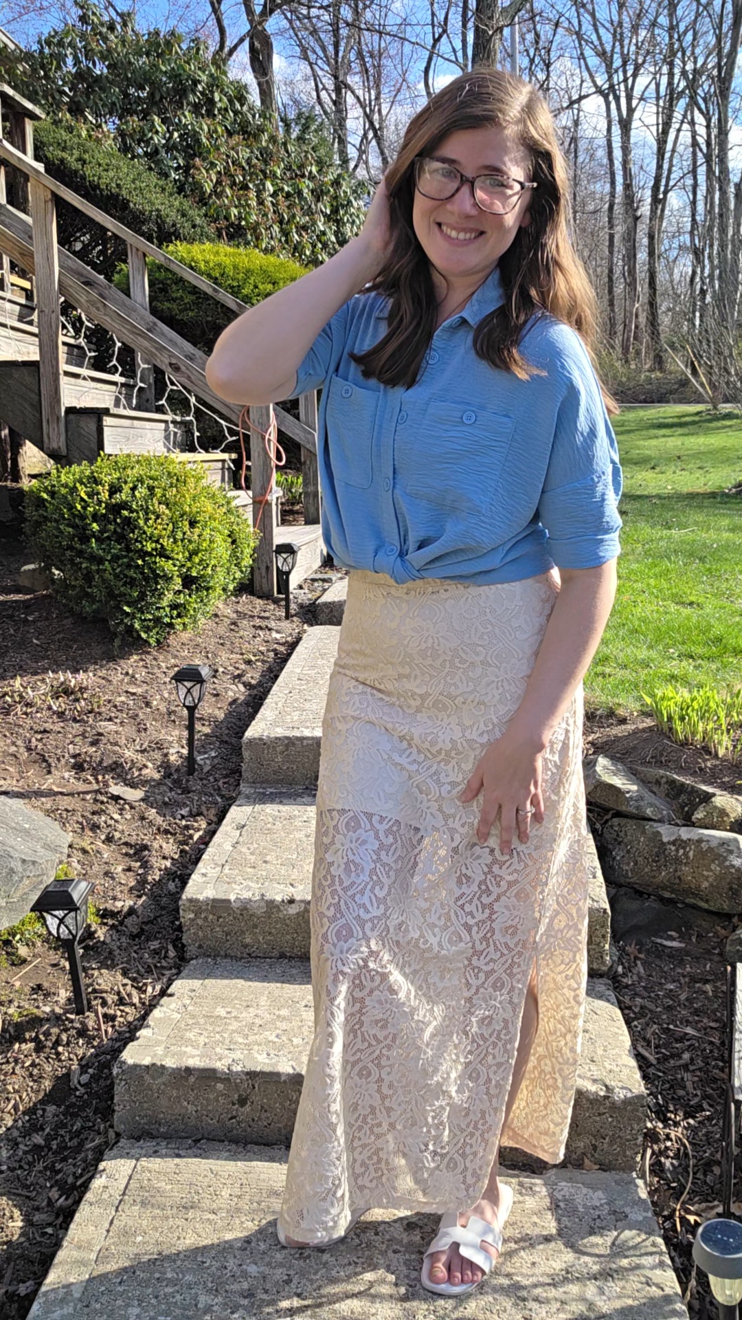 Courtney styling a blue blouse with a cream lace skirt outdoors