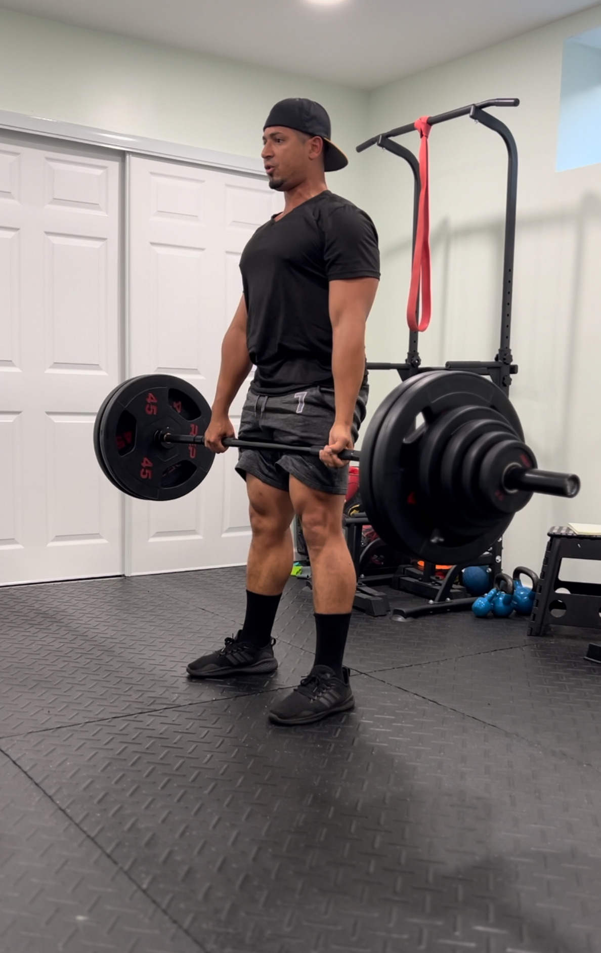 Coach holding a loaded barbell during a strength session