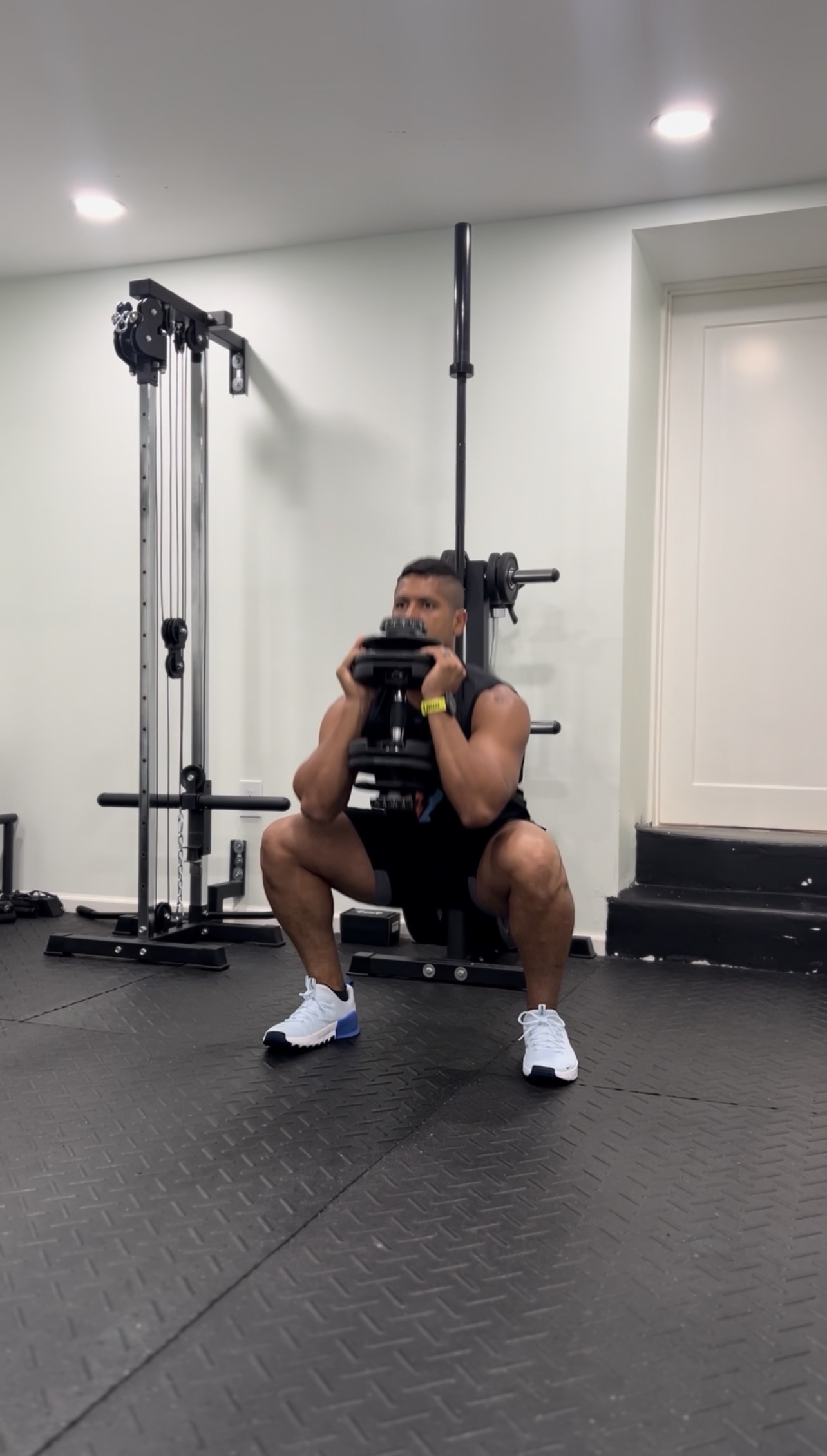Coach performing a goblet squat in a home gym