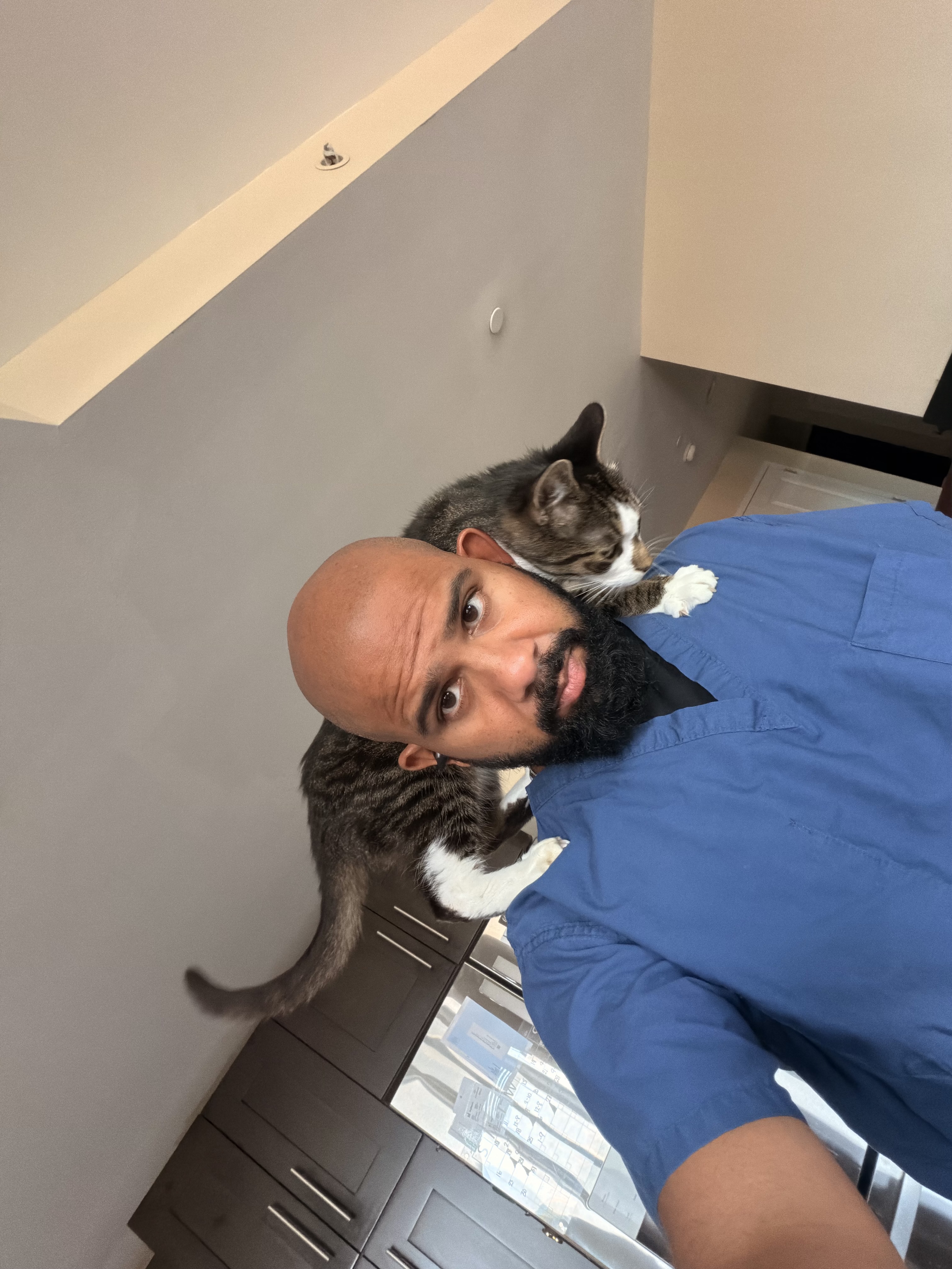 Brian at home with a cat resting across his shoulders